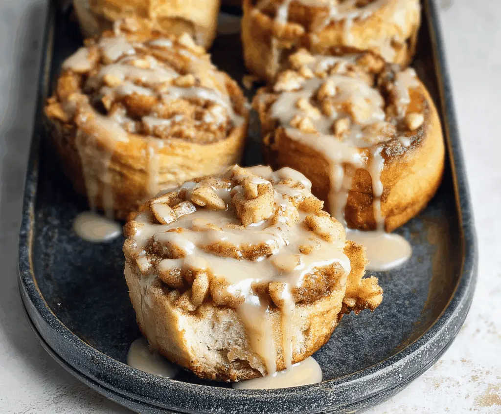 Delicious apple pie stuffed cinnamon rolls topped with caramel glaze and sprinkled cinnamon, perfect for breakfast or dessert