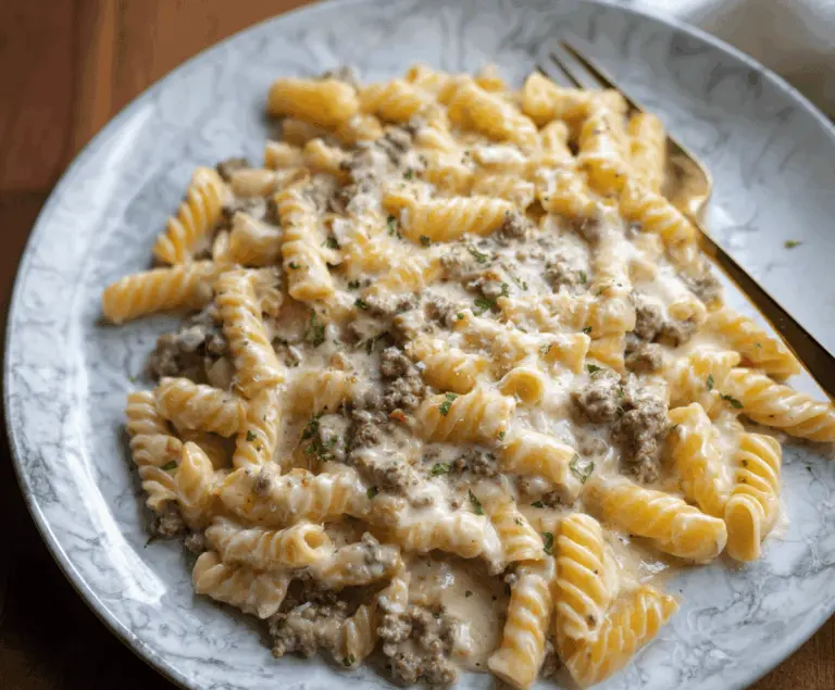 A delicious plate of creamy ground beef pasta garnished with herbs, featuring tender beef, creamy sauce, and al dente pasta for a hearty meal.