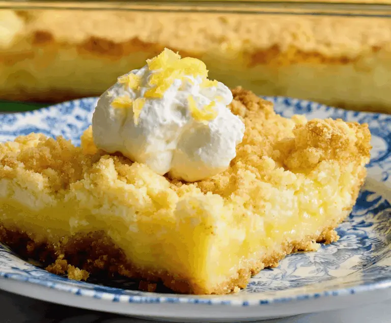 Delicious Tangy Lemon Cream Cheese Dump Cake with Buttery Crust, topped with fresh lemon slices and powdered sugar, served on a white plate