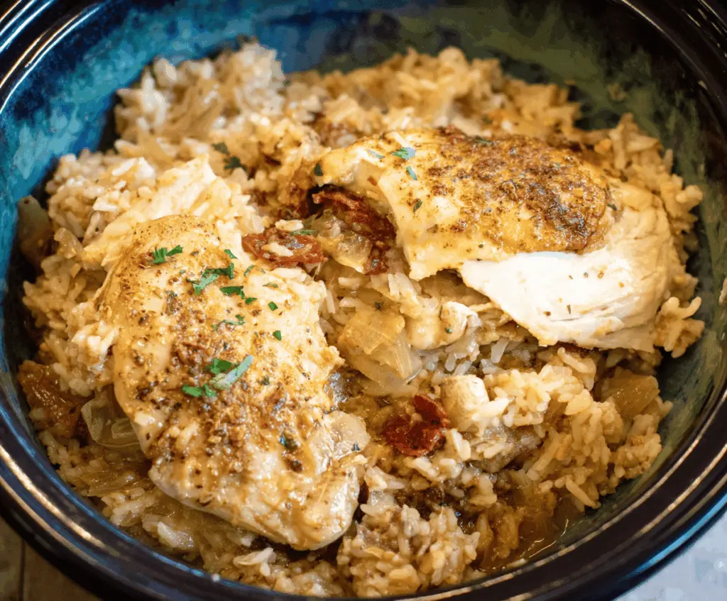 Delicious Crock Pot Chicken and Rice served in a bowl with fresh vegetables.