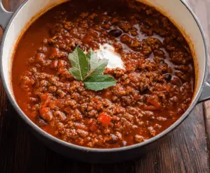Hearty no beans chili in a bowl topped with shredded cheese and fresh cilantro
