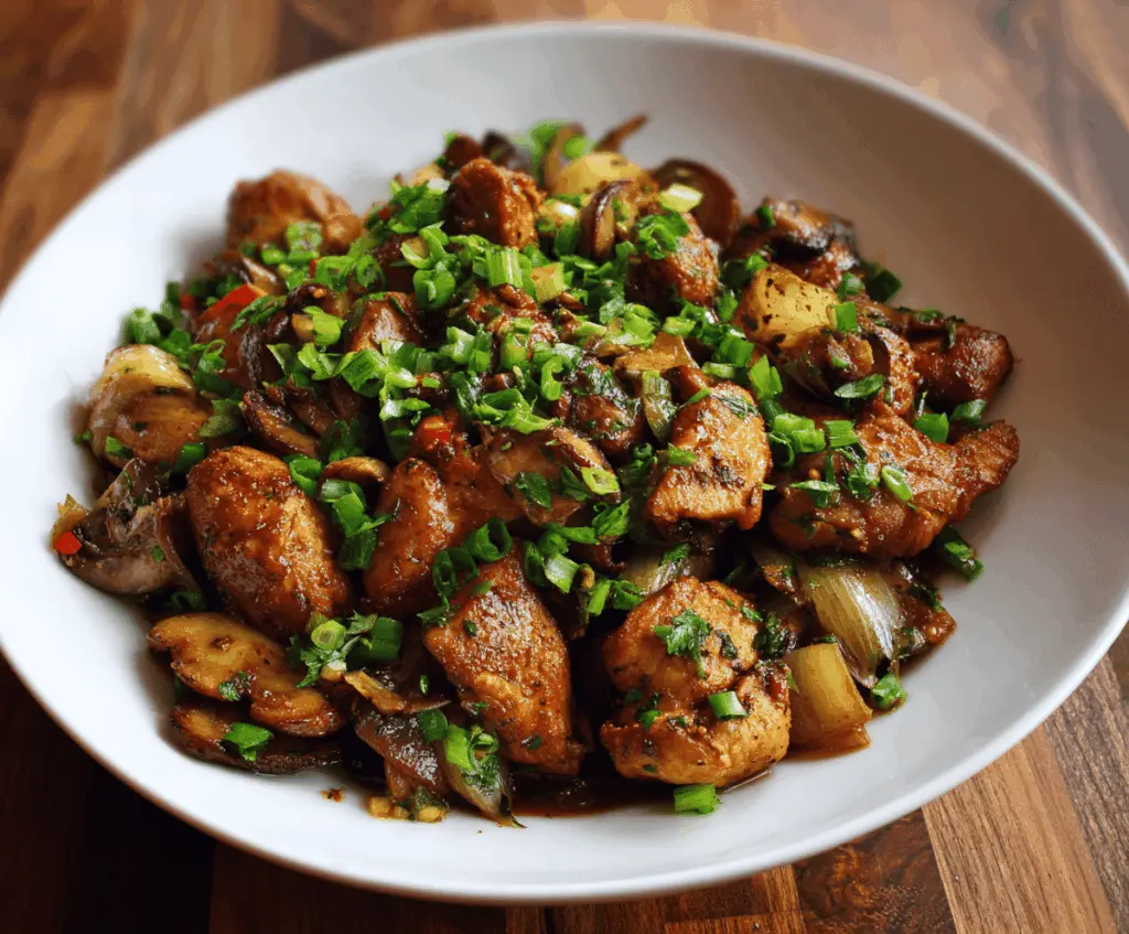 Delicious stir-fried Chinese garlic chicken garnished with green onions on a plate