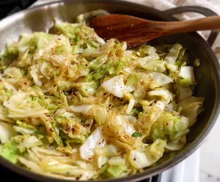 Delicious garlic butter sautéed cabbage served on a white plate, highlighting its golden crispy edges and tender interior.
