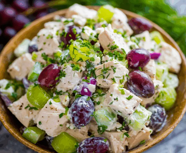 Healthy chicken salad with Greek yogurt, fresh vegetables, and herbs in a bowl, ideal for a nutritious meal.