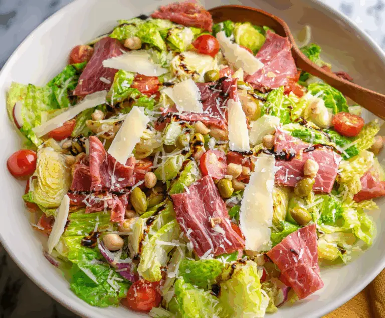 Colorful La Scala Chopped Salad with fresh vegetables and herbs on a white plate.
