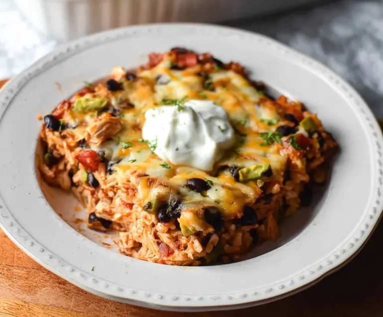 Delicious chicken burrito casserole topped with cheese and fresh toppings, perfect for a hearty meal