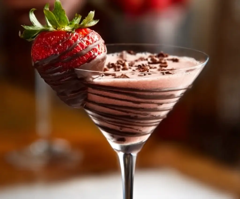 Delicious Chocolate Covered Strawberry Martini in a elegant cocktail glass with fresh strawberries and chocolate drizzle