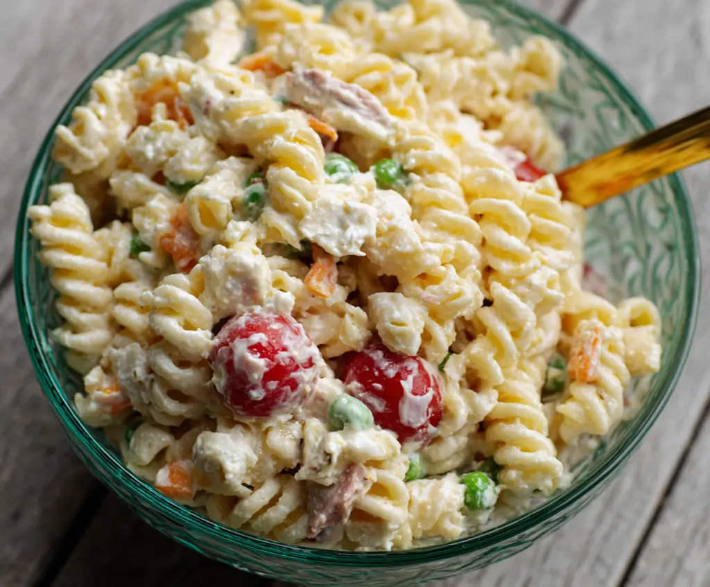 Creamy pasta salad with fresh vegetables and herbs served in a bowl for a light, flavorful meal.