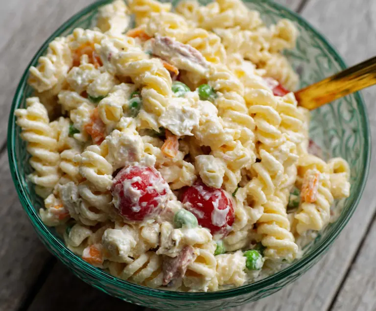 Creamy pasta salad with fresh vegetables and herbs served in a bowl for a light, flavorful meal.