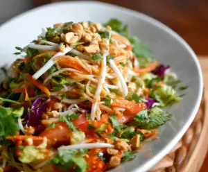 Fresh Spring Roll Salad with Peanut Dressing featuring colorful vegetables and crispy rolls.