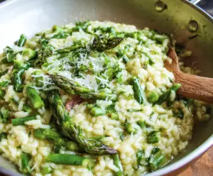 Creamy asparagus risotto garnished with fresh herbs and grated Parmesan cheese.