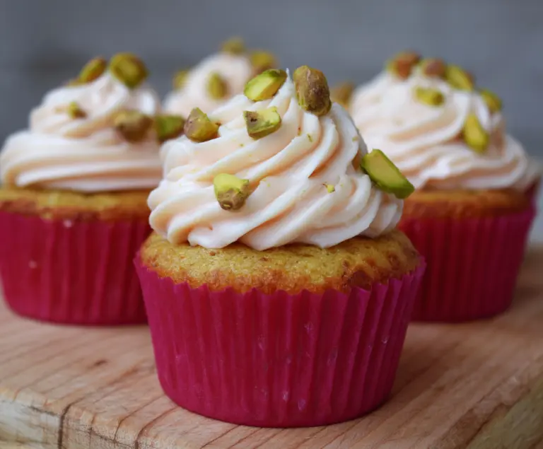 Delicious honey pistachio rosewater cupcakes topped with rose petals and pistachios.