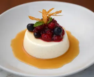 Delicious Orange Blossom Honey Panna Cotta topped with vibrant Berry Compote, perfect for a sweet dessert.