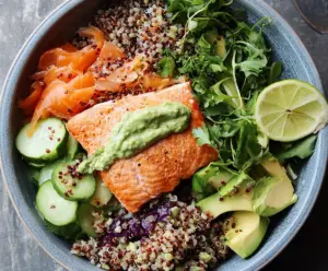 Healthy salmon and quinoa power bowl with fresh vegetables and herbs for a nutritious meal.