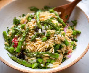 Fresh orzo salad with vibrant asparagus and colorful vegetables, perfect for a healthy lunch.